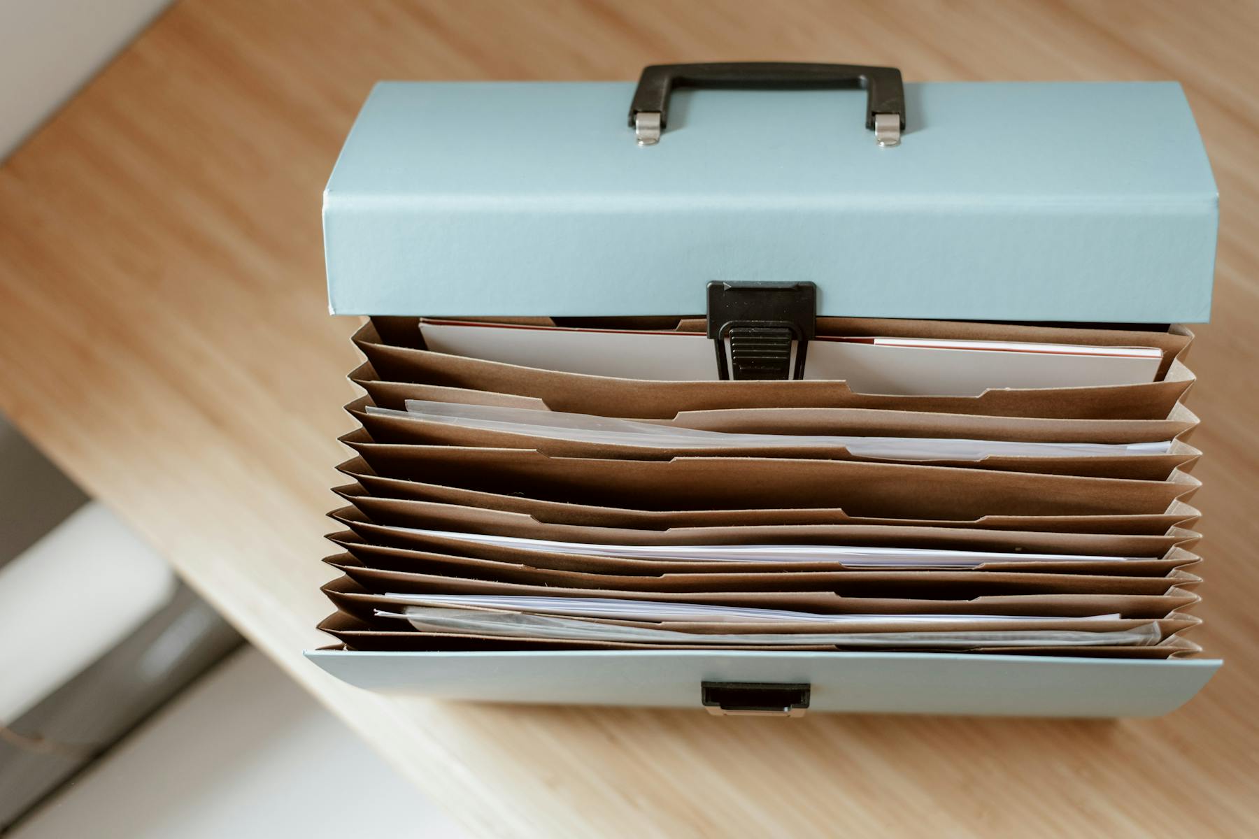 Accordion file organizer holds papers beside desk, supporting marketing strategy plan and content strategy review. Image by Anete Lusina (https://www.pexels.com/@anete-lusina)